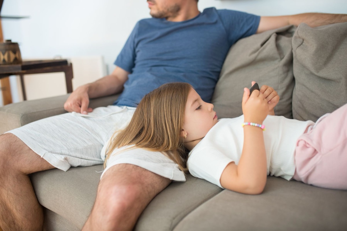 Parent sitting with a child who uses a smartphone